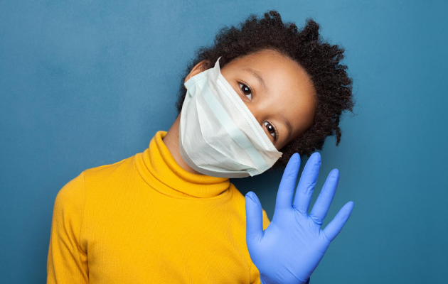 Photo of boy wearing mask and gloves.